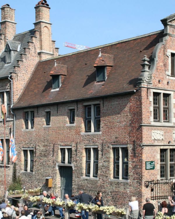 Das Originalgebäude Haus der Gerber aus Brüggge. Dort ist ein Fluss mit Menschen in einem Boot.