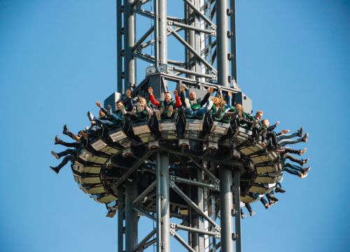 Der HIGHLANDER mit Gästen in der Gondel in luftiger Höhe. Im Hintergrund sind Felder.