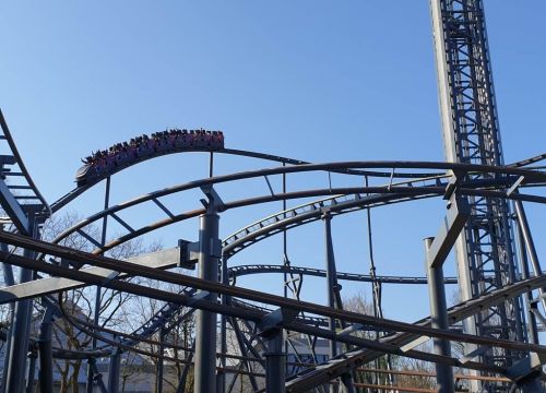 Die Achterbahn Nessi vor dem Looping oben auf dem Hügel. Die Gäste heben die Arme.