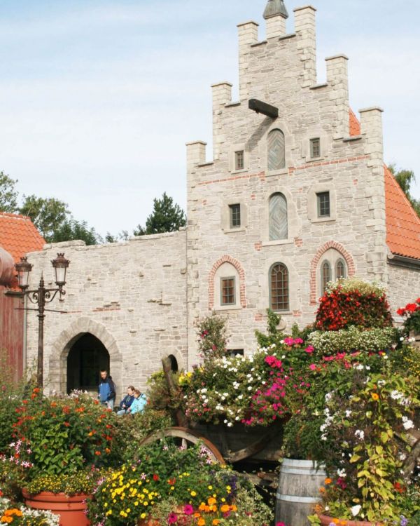 Die hanseatischen Arcaden. Im Fokus ist die alte Apotheke. Davor steht ein Karren mit Blumen.