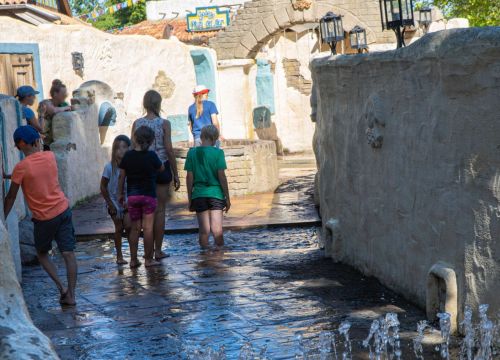 Auf dem Pfad Camino del Mar beobachten die Kinder das Wasser. Ein paar sind mit den Beinen drinnen.