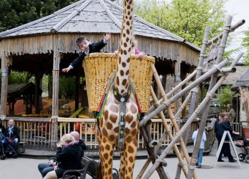 Im Korb auf den Rücken der Giraffe Akira sind zwei Kinder über eine Leiter gestiegen.
