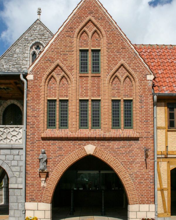Das Haus St. Petrus aus Bremen. Es ist ein Klinkerbau mit grünen Fensterrahmen und einem Bogen.