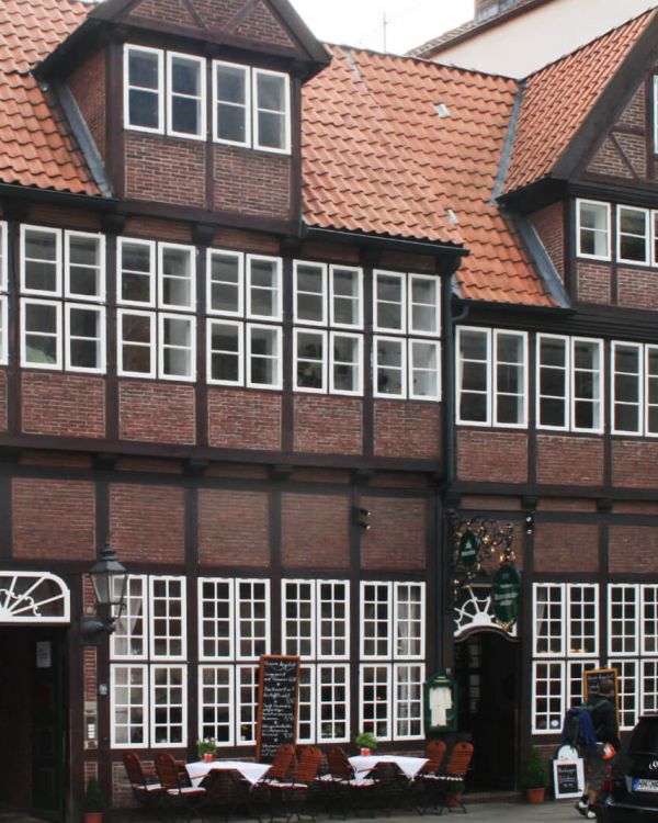 Das Originalgebäude der Krameramtsstuben aus Hamburg. Es ist ein Fachwerkhaus mit weißen Fenstern.