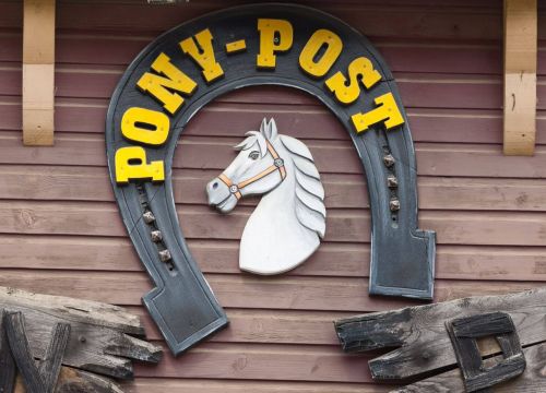 Ein Hufeisen mit dem Namen und ein Pferd ergeben das Logo der Attraktion Pony-Post.