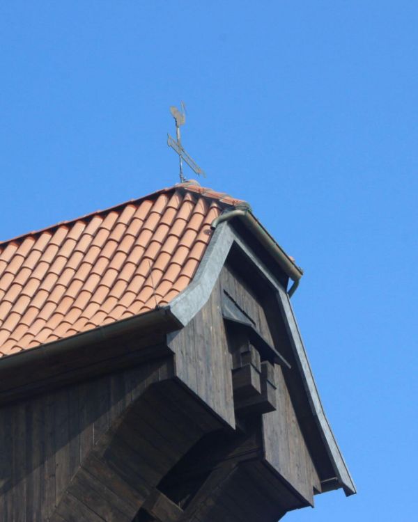 Der überhängende Giebel des Krantor von Danzig mit einem Wetterhahn.