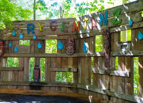 Die Wand für den Regentanz. Auf ihr sind große Regentropfen und Indianer Masken.