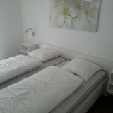 Ein Doppelbett mit Nachtisch und einem Bild über dem Bett.