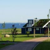 Ein Haus von weiter weg. Ein Weg führt zum Haus. Im Hintergrund die Ostsee.