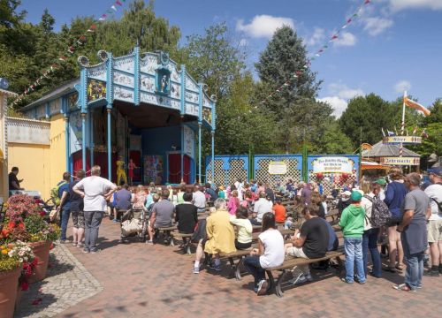 Die Freilichtbühne von vorne. In den Sitzreihen sitzen Gäste und schauen auf das Show Programm.