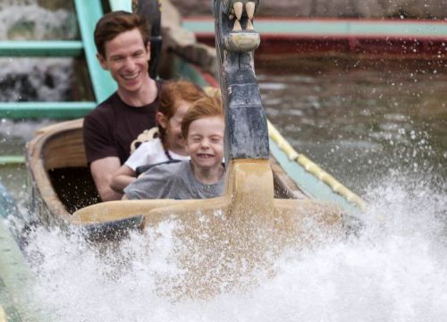 In der Sturmfahrt der Drachenboote schiebt ein Boot mit Gästen spritzendes Wasser vor sich her.