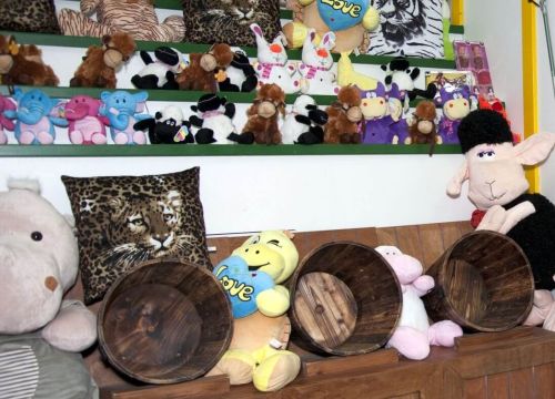 Neben den drei Eimer liegen Kuscheltiere. Darüber Regale auf den auch Kuscheltiere sitzen.