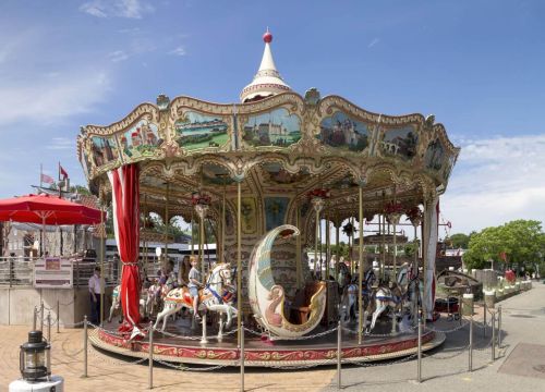 Das HANSE-Karussell von außen. Es hat bunte Bilder oben am Rahmen und verschiedene Figuren.