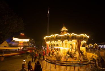 Der HANSA-PARK-Express, der HANSE-Flieger und das HANSE-Karussell ist erleuchtet und bewegen sich.