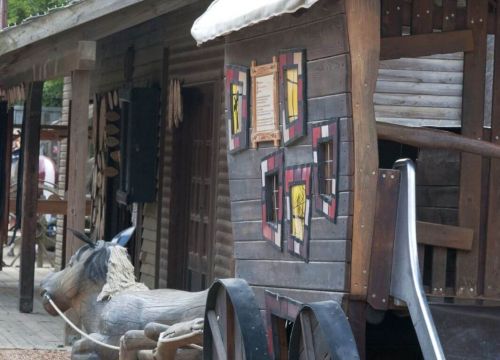 Die Postkutsche von hinten. Man sieht die Rutsche und ein liegendes Pferd aus Holz.