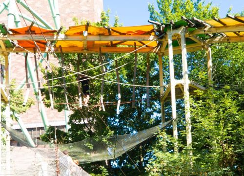 Ein Kletterer im Hochseilgarten Navajo Trail. Der Pfad führt durch die Baumkronen durch.
