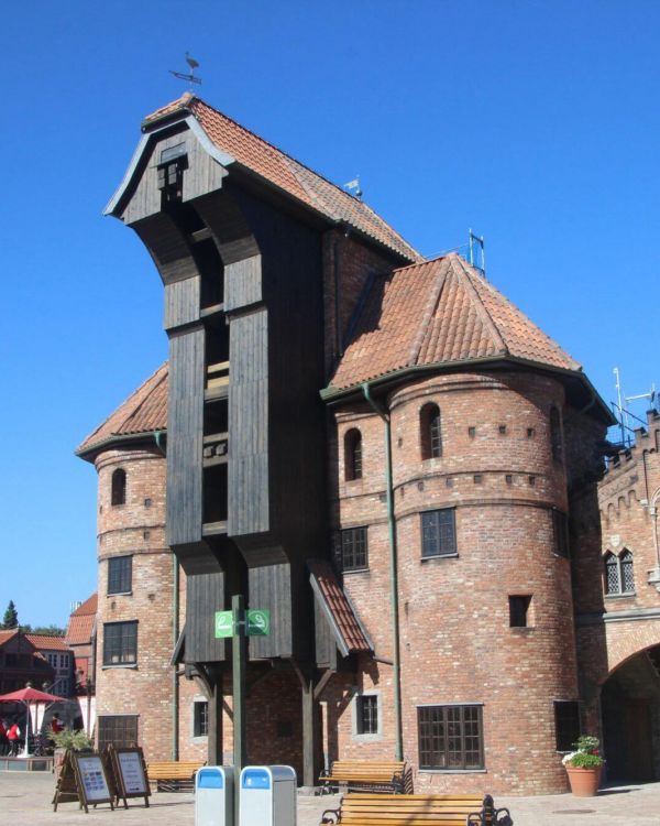 Das Krantor von Danzig von vorne. Davor sind Schilder und ein Schild für eine Raucherinsel.