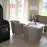 Couch mit zwei Sesseln, einen Couchtisch und einem Kamin.