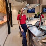 Junge Frau in HANSA-PARK Arbeitskleidung hinter einem Tresen steht und ist der Kamera zu gewandt.