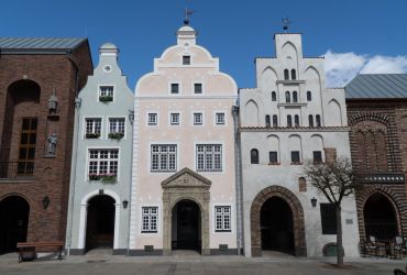 Die Drei Gebäude mit dem Namen die Drei Brüder aus Riga. Sie sind alle in hellen Farben.