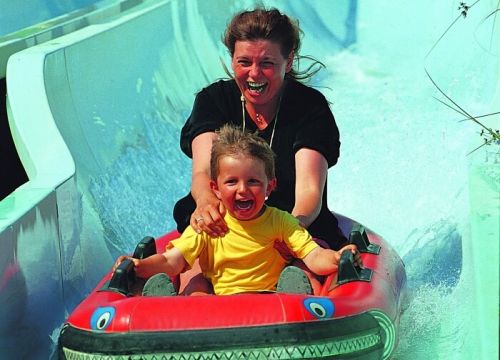 Frau und Kind haben bei der Abfahrt in einem Schlauchboot der Attraktion Barracuda Slide viel Spaß.