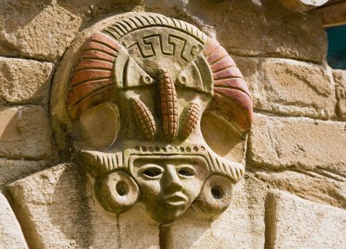 Am Camino del Mar ist ein Kopf mit einer Krone. Federschmuck und drei Maiskolben sind auf der Krone.