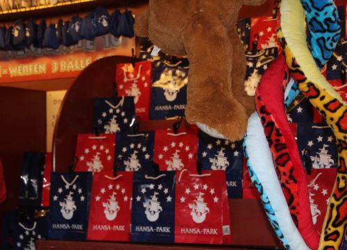 Roten und blaue Tüten des Stands Dosenwerfen und Tütenangeln. Kuscheltier hängen von der Decke.