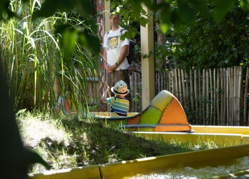 Ein Junge fährt mit einem Kanu auf dem Indian River. Ein Mann steht daneben.