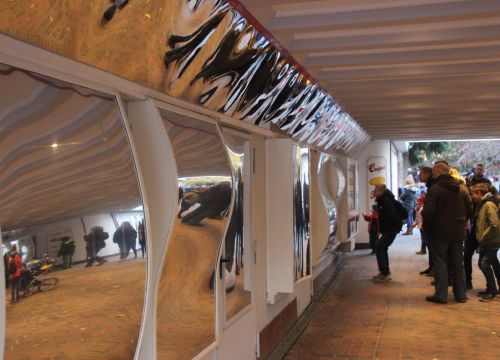 In der Spiegelgalerie stehen Familien vor dem Spiegel und schauen sich an.