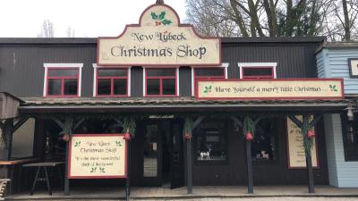 Der Christmas-Shop von außen. Die Tür steht offen. Große Schilder weisen auf den Shop hin.