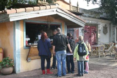 Eine Hütte bei der die Gäste anstehen. Ein Mitarbeiter kümmert sich um die Gäste.