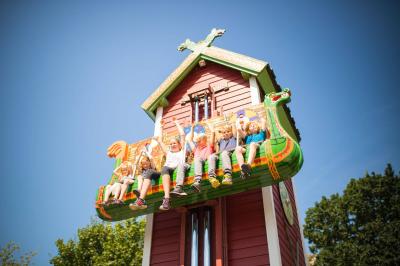 In den Sitzen von Elins Luftreise sitzen Kinder. Sie heben die Arme. Sie sind ganz oben.