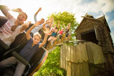 Der Wagen der Schlange von Midgard fährt die Schiene runter. Die Gäste haben die Arme hoch.