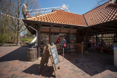 Beim Kiosk an der Schiffschaukel stehen Gäste und bekommen von der Servicekraft ihre Bestellung.