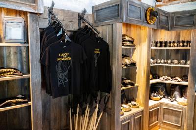 Regale des Ride Shop Flucht von Novgorod. An zwei Kleiderstangen in Form einer Axt hängen T-Shirts.