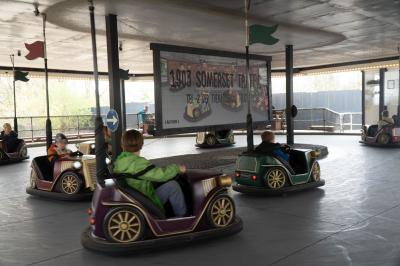 Verschiedene motorisierte Fahrzeuge fahren mit Kindern im Kreis