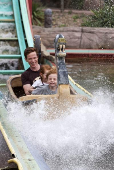 In der Sturmfahrt der Drachenboote schiebt ein Boot mit Gästen spritzendes Wasser vor sich her.