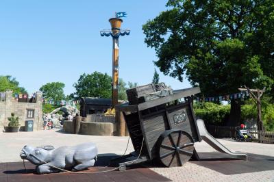 Ein liegender Esel. Dahinter ein Karren mit einer Rutsche. Im Hintergrund Awildas Welt.