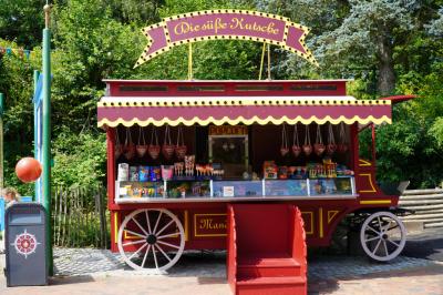 Die rote Mandelkutsche mit einer Treppe für Kinder. Dort hängen und stehen ganz viele Süßigkeiten.