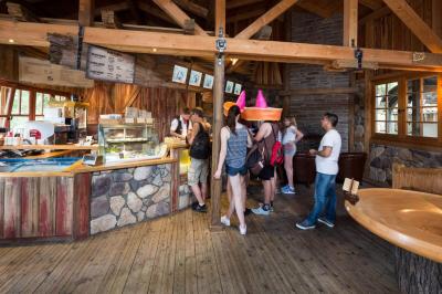 Am Tresen des Ride-Shops der Crazy Mine stehen Gäste an. Manche schauen auf die Ride Fotos.