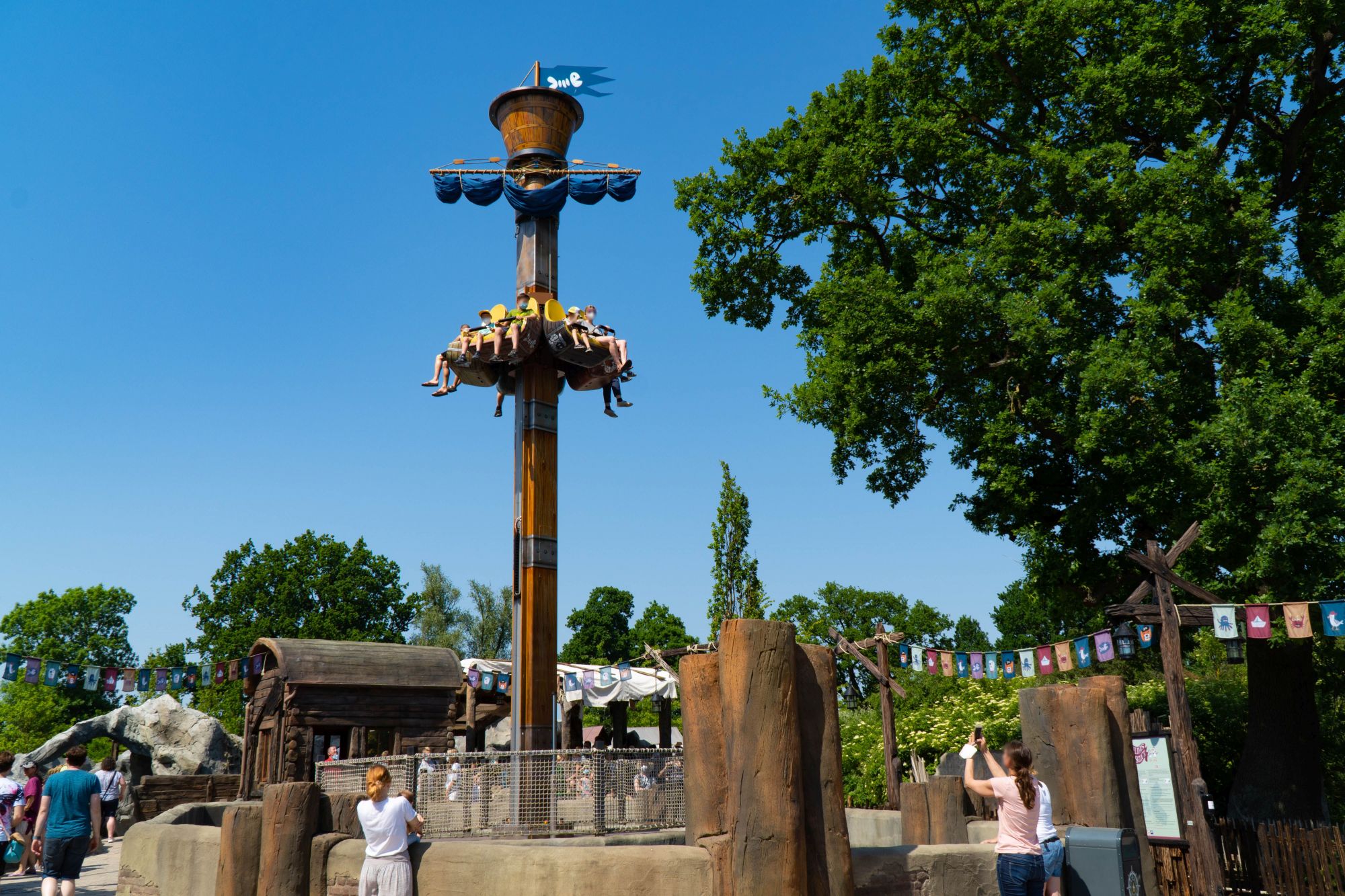 Vorne ist die Attraktion Awildas Ausguck. Es sitzen Gäste in den Sitzen. Rundherum warten Gäste.