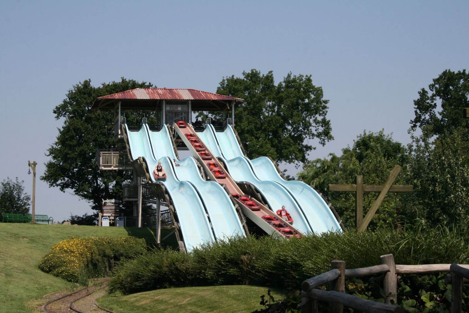 Auf den Rutschen der Attraktion Barracuda Slide sind Boote mit Gästen auf den Weg nach unten.