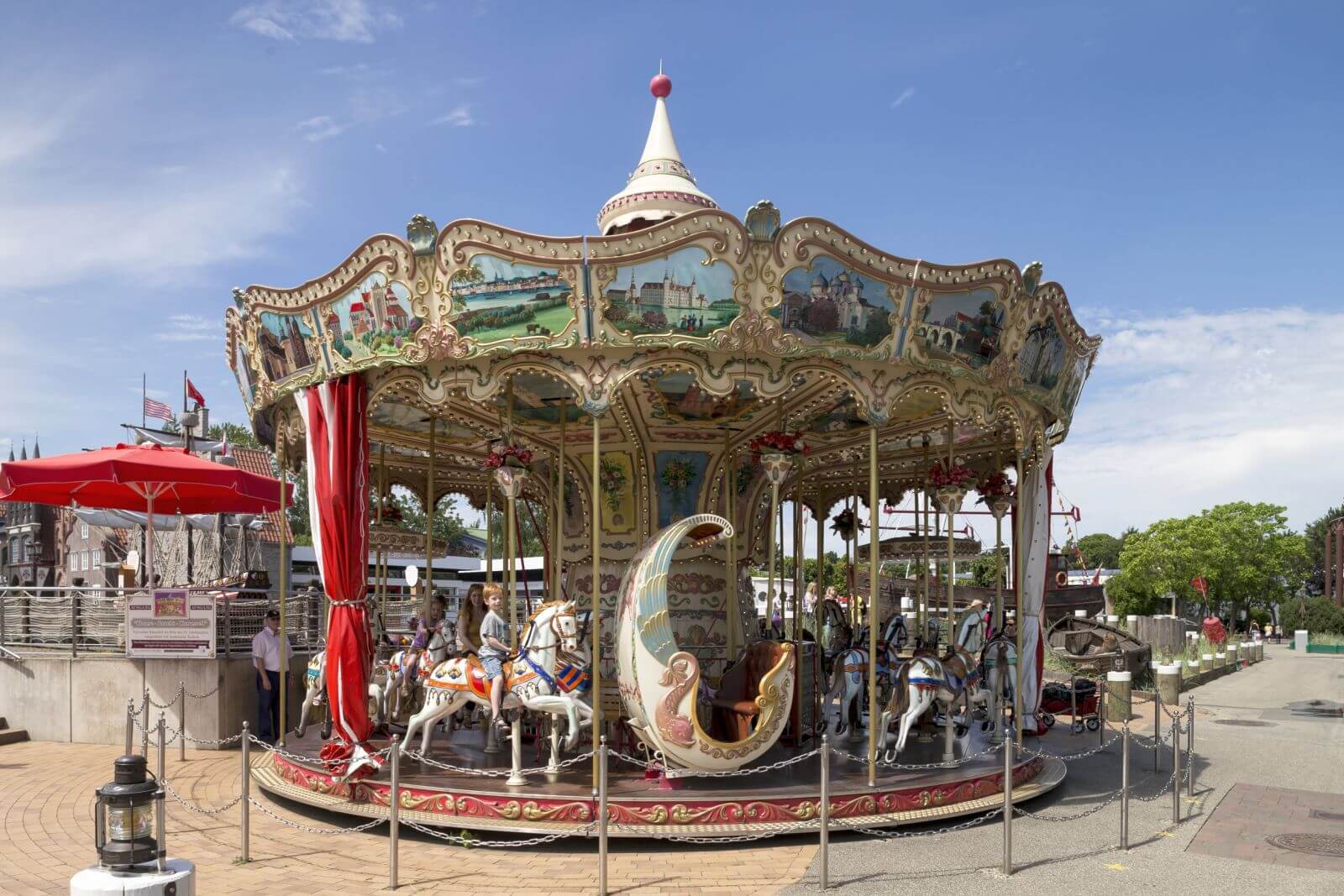 Das HANSE-Karussell von außen. Es hat bunte Bilder oben am Rahmen und verschiedene Figuren.