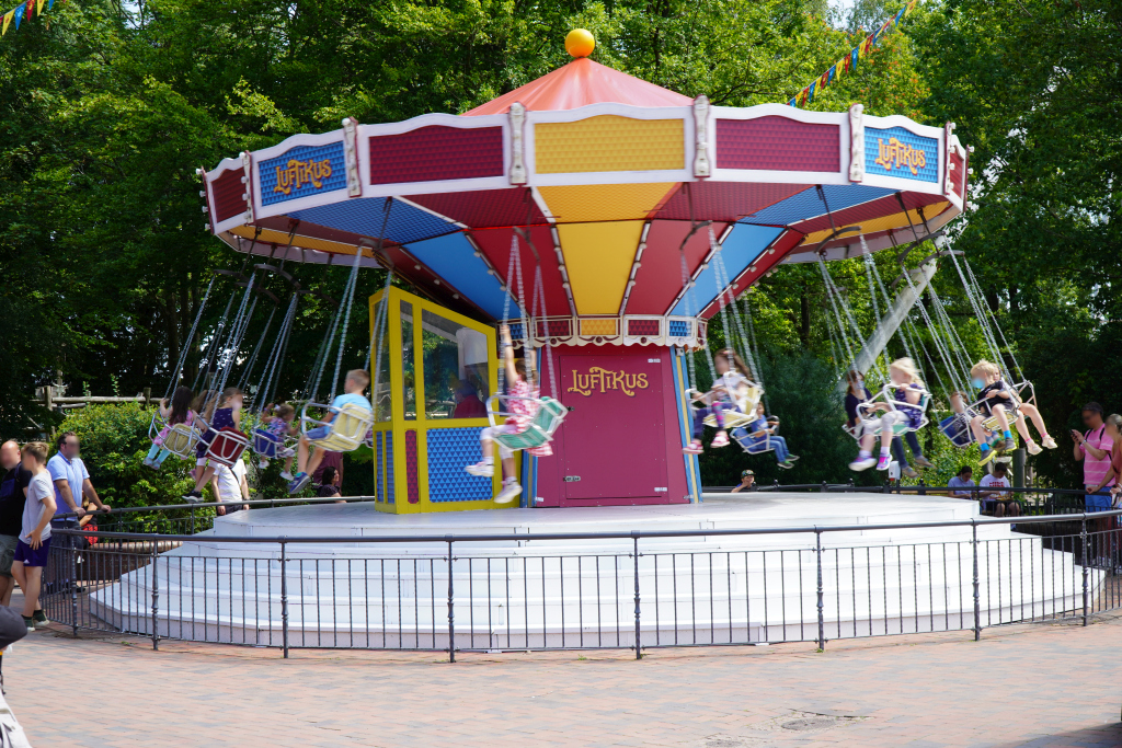In dem Kinder-Kettenkarussell sitzen viele Kinder und genießen die Fahrt.