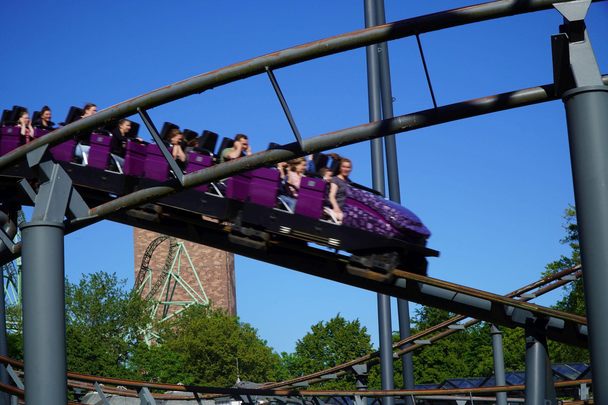 Der Zug der Achterbahn Nessie fährt in den Tunnel ein. Die Gäste halten sich fest oder die Ohren zu.
