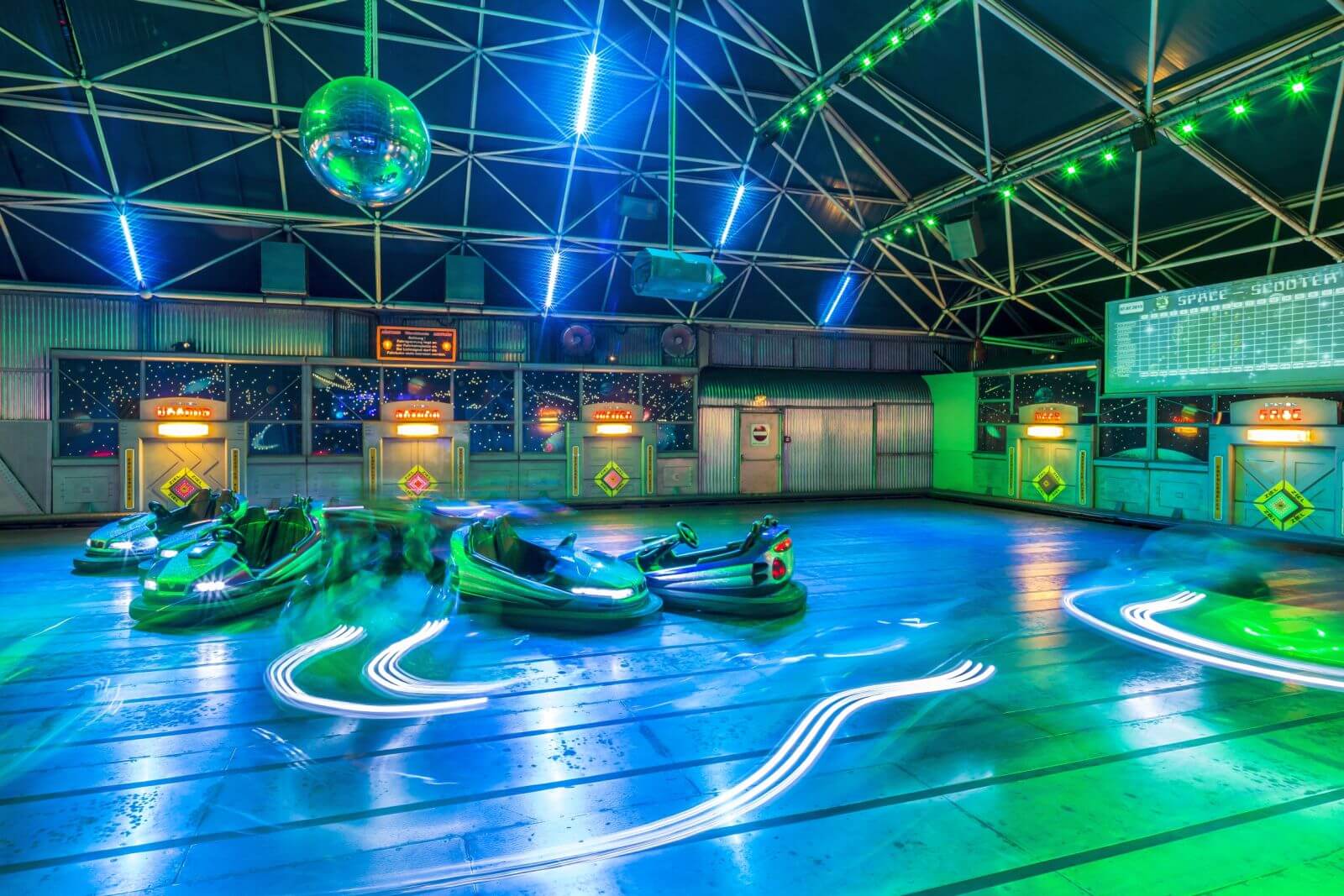 Die Autos der Attraktion Space-Race fahren schnell von einem Planeten zum anderen.