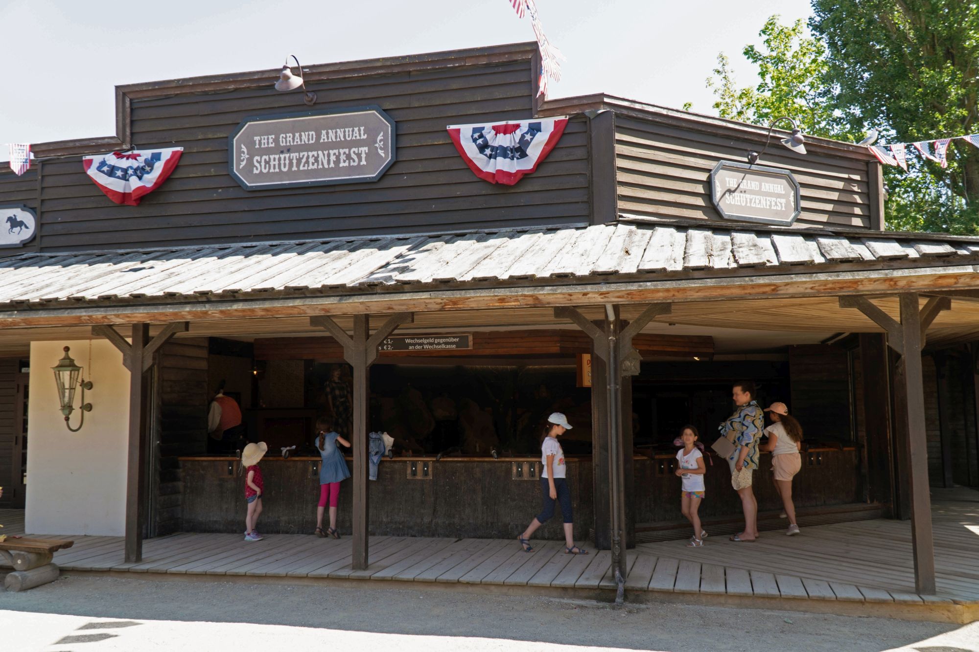Ein Gebäude von außen. Vier Kinder und zwei Erwachsene stehen vor den Schießmöglichkeiten.
