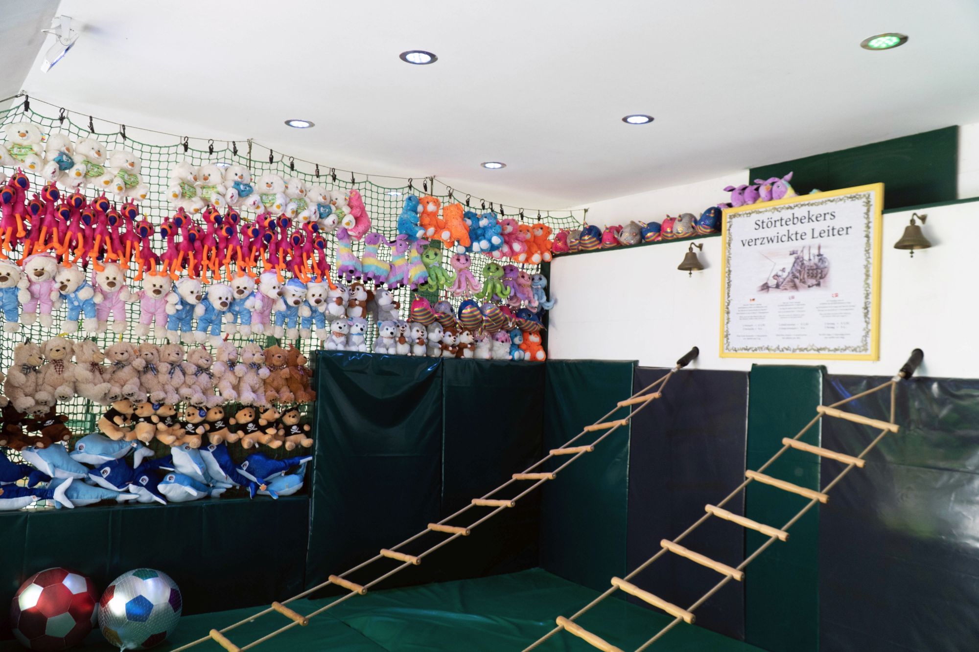 Nebeneinander sind zwei Strickleitern an der Wand befestigt. Am Ende hängt jeweils eine Glocke.