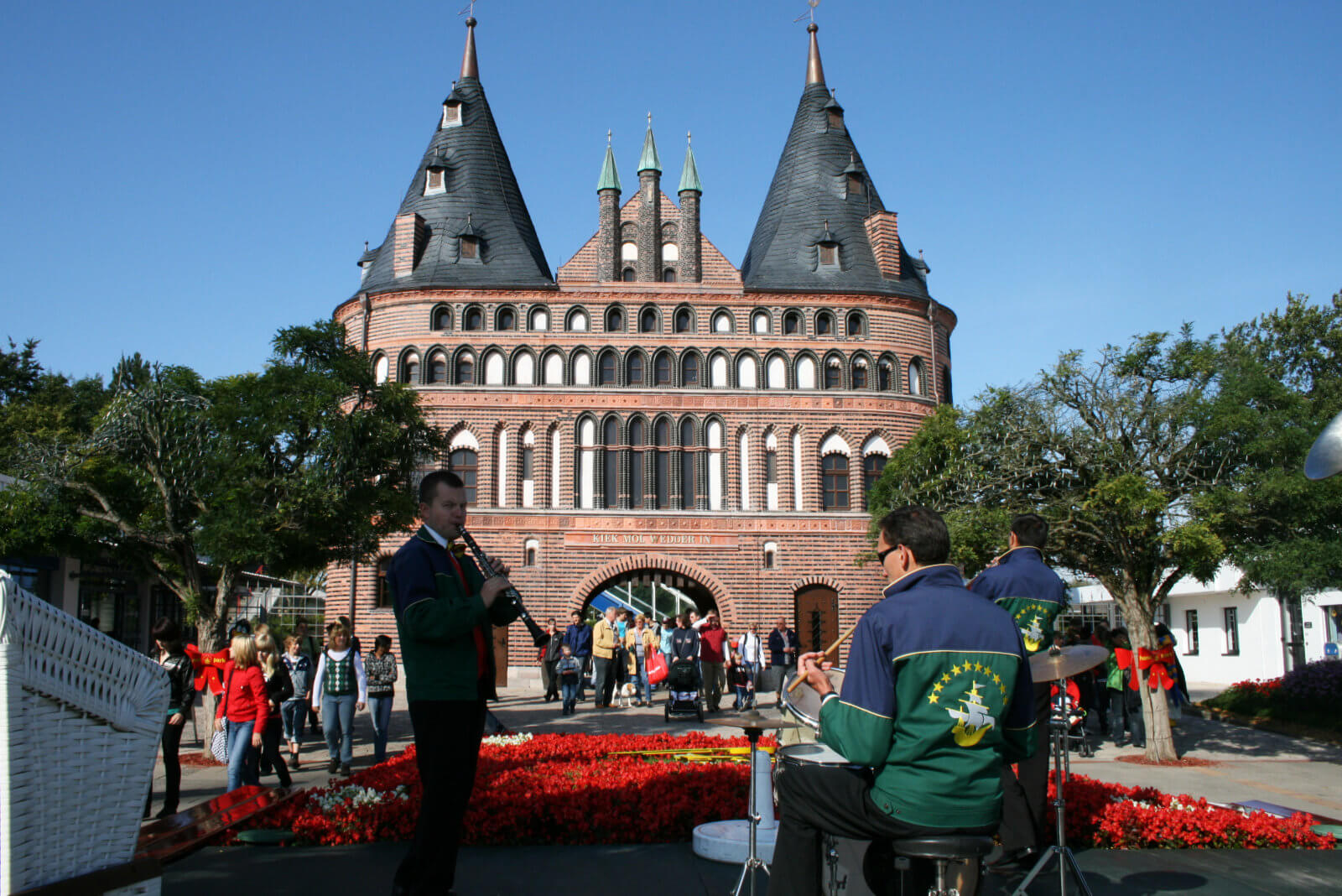 Eine Band spielt auf einer Bühne. Die Gäste strömen durch den Eingang des Holstentors.