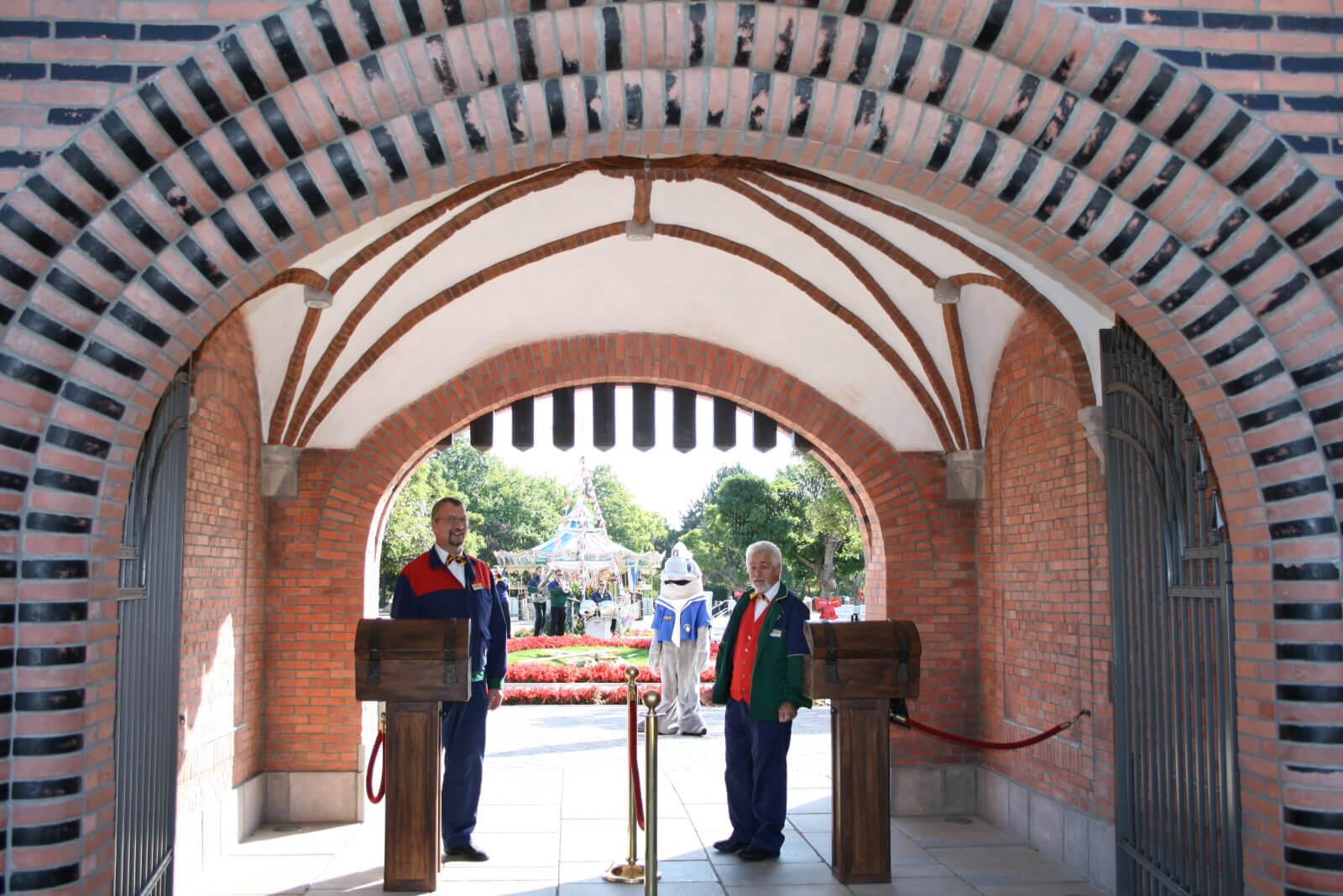 Der Einlass des Holstentor früher. Zwei Mitarbeiter stehen und warten.